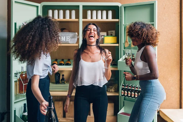 Trzy wielorasowe kobiety pijące i tańczące w nowoczesnym mieszkaniu — Zdjęcie stockowe