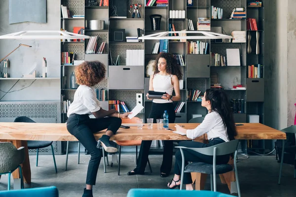 Drie jonge multiraciale zakenvrouwen plannen een nieuw project in coworking — Stockfoto