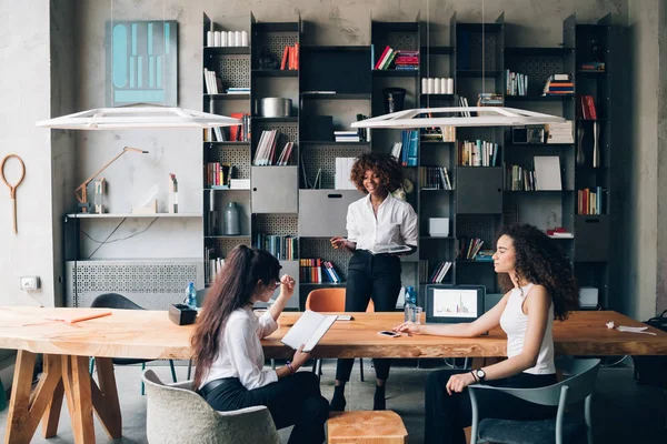 Drie jonge multiculturele collega 's bespreken project in moder — Stockfoto