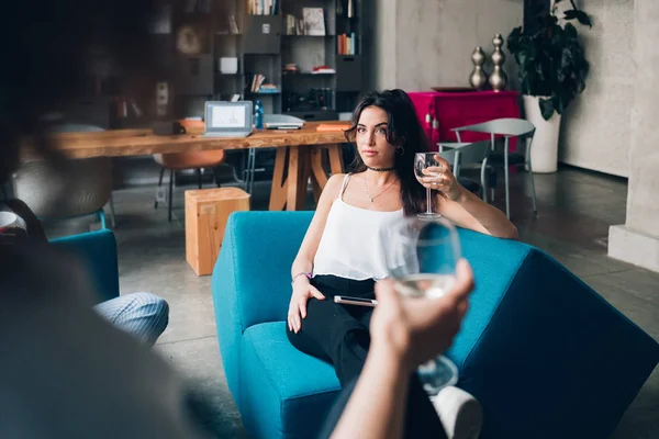 Duas jovens mulheres sentadas no apartamento moderno e bebendo juntas — Fotografia de Stock