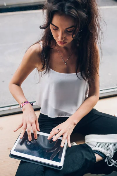 Jonge Kaukasische student schrijven en werken met tablet in modern kantoor — Stockfoto