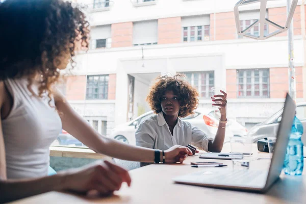 Twee jonge zakenvrouwen praten in modern kantoor — Stockfoto