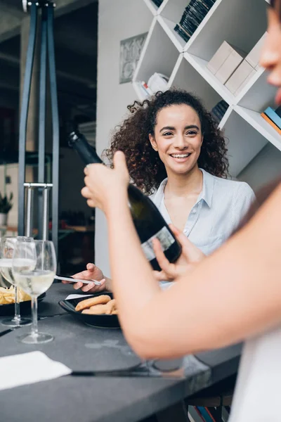 Zwei junge kaukasische Frauen trinken Wein in einem modernen Restaurant und feiern — Stockfoto