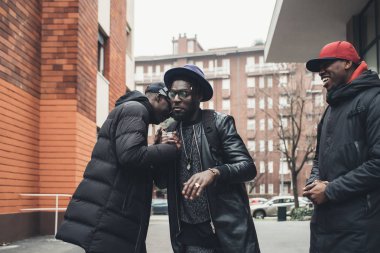 Sokakta selamlaşan üç Afrikalı adam