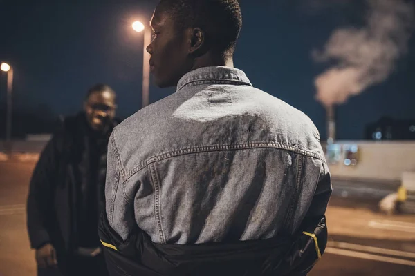 Perfil do jovem homem africano posando na rua e mostrando as costas — Fotografia de Stock