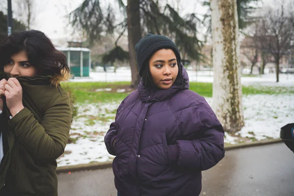 Porträt von zwei brünetten Frauen, die an einem Wintertag auf der Straße laufen — Stockfoto