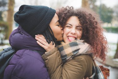 Açık havada poz veren iki genç kız arkadaş. 