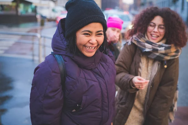 Молодые женщины, стоящие на улице и улыбающиеся — стоковое фото