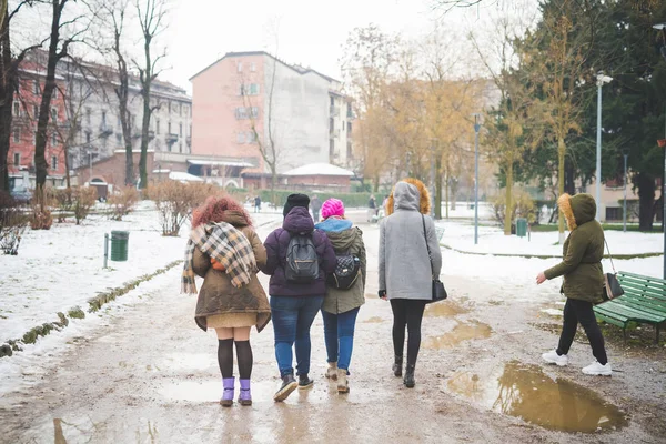 Grupa kobiet spacerujących po ulicy i pokazujących plecy — Zdjęcie stockowe