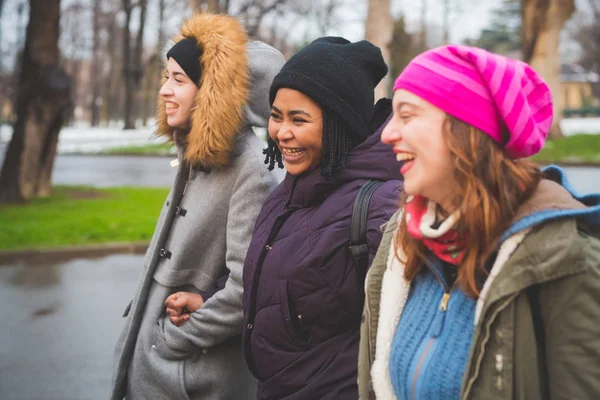 Tři mladé ženy se smějí a chodí venku v městském parku — Stock fotografie