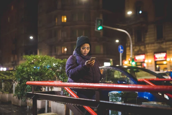 รูปภาพของหญิงสาวชาวแอฟริกันที่ใช้สมาร์ทโฟนใกล้รถไฟใต้ดิน — ภาพถ่ายสต็อก