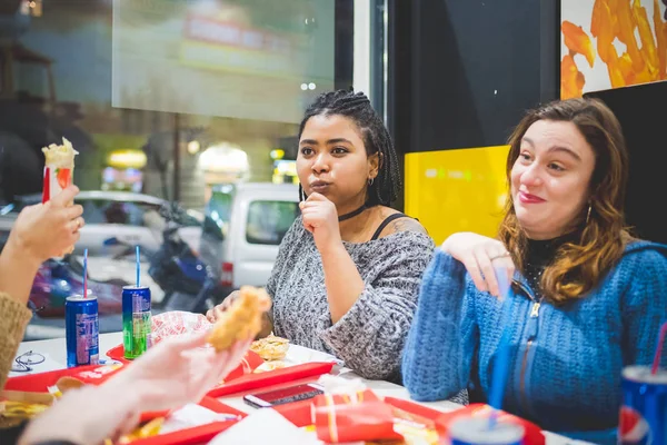 Grupa młodych dziewczyn jedzących posiłek w fast foodach — Zdjęcie stockowe