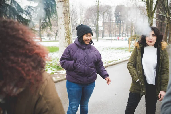 Grupo de jóvenes mujeres multirraciales fumando cigarrillo en la calle — Foto de Stock