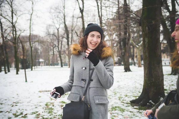 Porträt einer jungen kaukasischen Frau, die mit Freunden im Park steht — Stockfoto