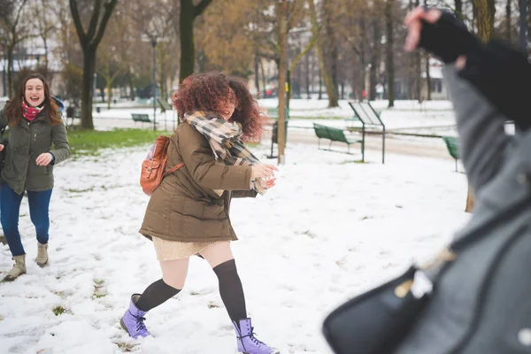 Portrét mladé ženy hrající v parku se sněhovou koulí — Stock fotografie