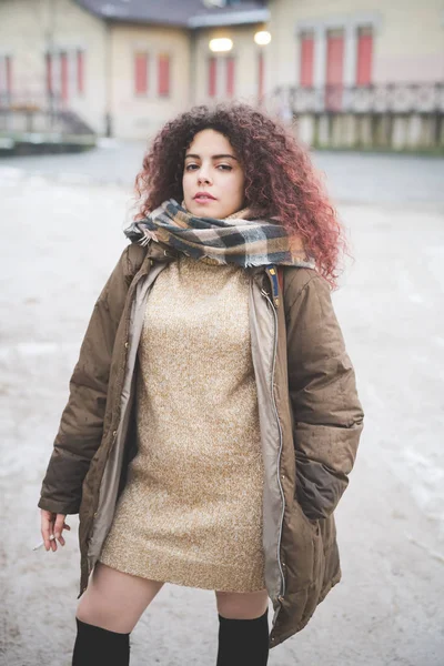 Portret van jonge krullende vrouw poseren in het park tijdens de winter dag — Stockfoto