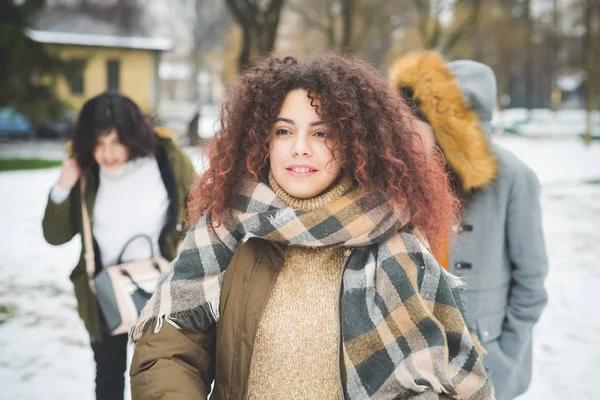 Genç esmer kadın arkadaşlarıyla parkta yürüyor. — Stok fotoğraf