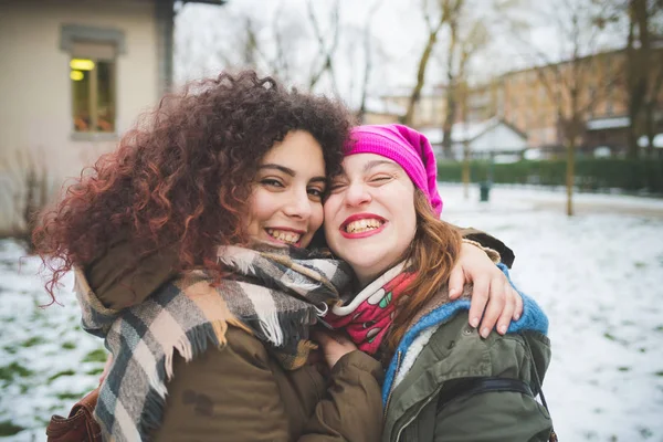 Portrait of two young women standing in park and hugging — Stock Photo, Image