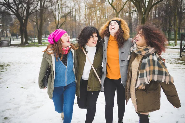 Grupp flickvänner promenader i parken med snö täcka och har — Stockfoto