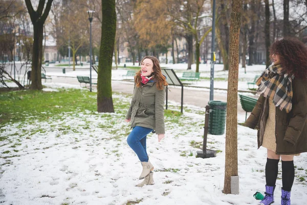 İki mutlu kadın parkta kar örtüsüyle dolaşıyorlar. — Stok fotoğraf