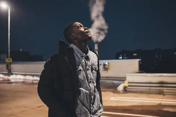 Retrato de un joven africano de pie en la calle y mirando más lejos — Foto de Stock