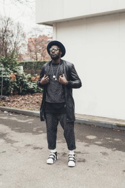 Genç Afrikalı adam tek başına dikiliyor ve ileri bakıyor.