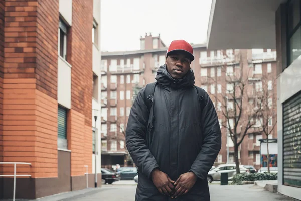 Retrato de un joven africano parado en la calle y mirando — Foto de Stock