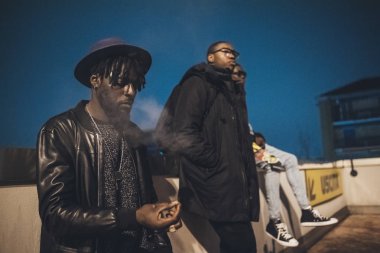 Üç genç Afrikalı park yerinde birlikte poz veriyor.