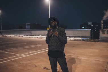 Genç Afrikalı adam park yerinde poz veriyor. 