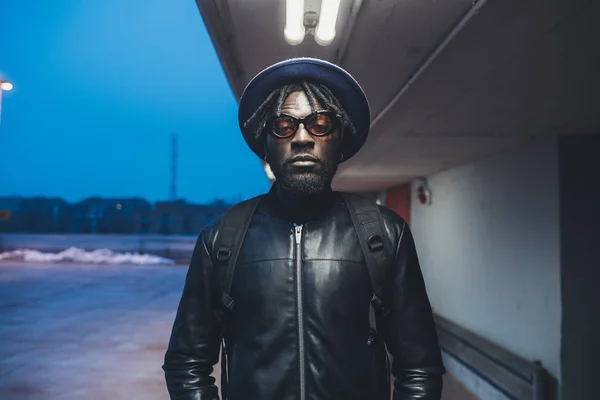 Retrato de un joven negro de pie en la calle y mirando c — Foto de Stock