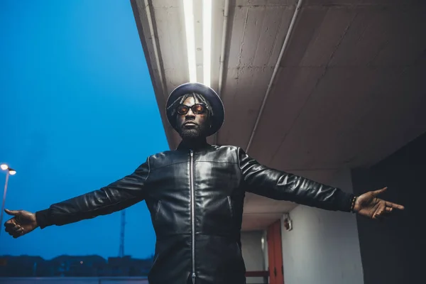 Porträtt av ung svart man står utomhus med öppna armar utseende — Stockfoto