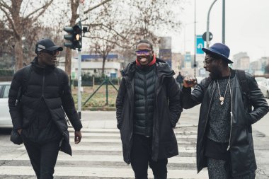 Üç Afrikalı genç adam konuşuyor ve birlikte eğleniyorlar.