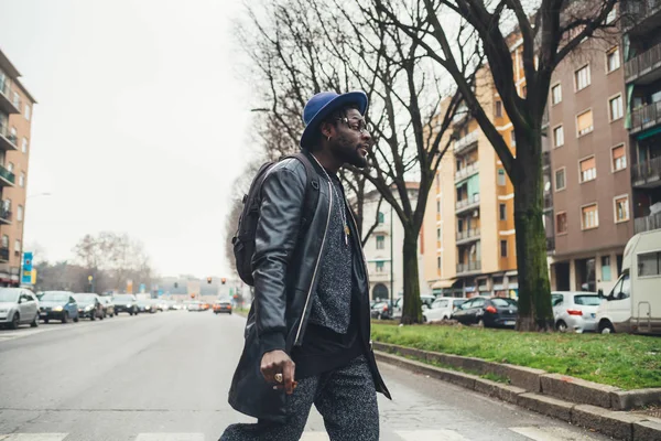 Jeune homme africain debout dans la rue et fumant le cigare — Photo