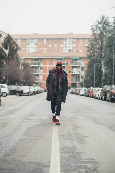 Jonge zwarte man lopen in de straat en op zoek camera glimlachen — Stockfoto