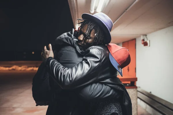 Twee jonge Afrikaanse mannen buiten samen knuffelen plezier hebben — Stockfoto