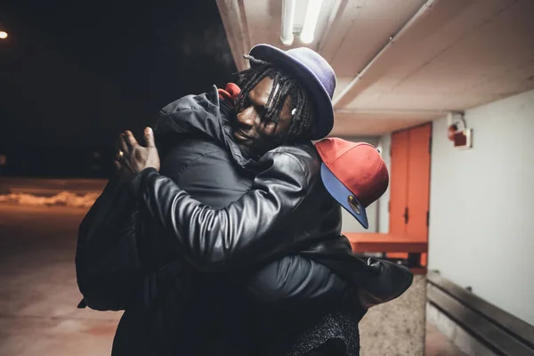 Twee jonge mannen buiten parkeerplaats groeten knuffelen — Stockfoto