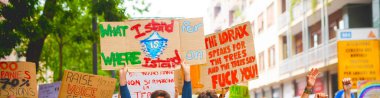 Grev protestolarında iklim değişikliği için tırmanan grev panolarını tutan insanlar - iklim politikalarında değişiklik olduğunu iddia eden aktivist