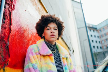 Genç kendinden emin afro kadın kameraya bakıyor.