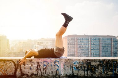 Dışarıda antrenman yapan genç bir adam. Şehirde spor yapan güçlü bir adam.