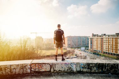 Tepedeki genç sporcu Panorama 'ya bakıyor Sırt çantalı Panorama' ya bakıyor