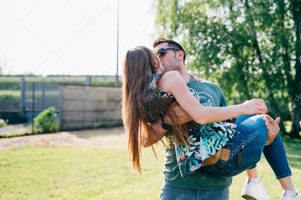 young couple in love outdoor hugging and kissing - getting away from it all, happiness, relationship concept