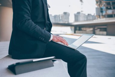 Bilgisayar kullanarak tanınmayan profesyonel iş adamı - orta bölüm iş adamı uzaktan kumandalı klavye defteri yazarak çalışıyor