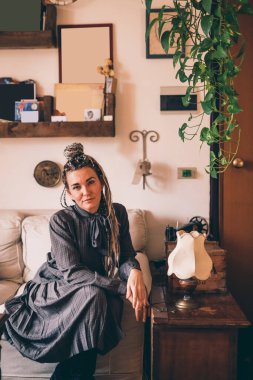 Evdeki güzel, yetişkin kadın portresi. Kapalı alanda gülümseyen kameralı, kaygısız kadın. 