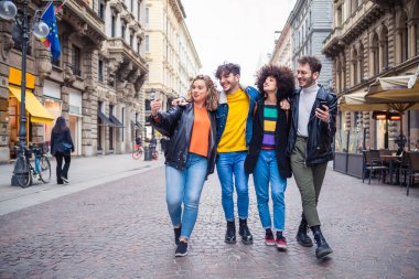 Bir grup arkadaş dışarı çıkıp eğleniyorlar - arkadaşlar turist olarak selfie çekiyorlar - gezgin, sosyal, birliktelik konsepti