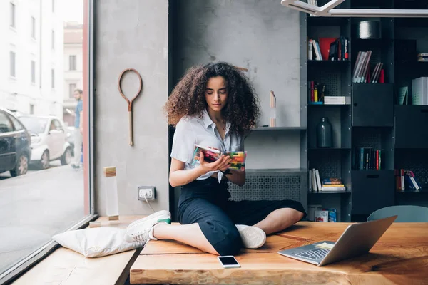 Junges Mädchen Sitzt Auf Tisch Und Liest Buch — Stockfoto