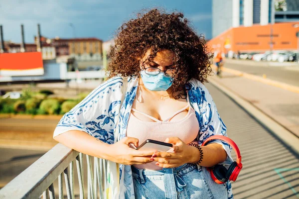 Νεαρή Γυναίκα Φορώντας Μάσκα Χρησιμοποιώντας Smartphone Διαφορετική Γυναικεία Εξωτερική Παρακολούθηση — Φωτογραφία Αρχείου