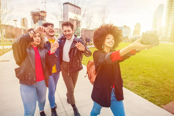 Çok ırklı bir grup arkadaş dışarıda video kaydediyor- farklı arkadaşlar selfie çekiyorlar - paylaşım, vlogger, sosyal ağlar konsepti