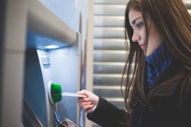 Young woman using atm - Caucasian female banking using automatic machine - transacrion, money, banking concept clipart