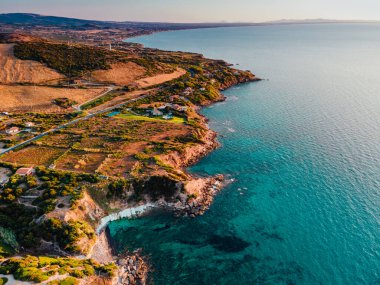 İtalya, Sardinya 'da kıyı şeridi ve yakındaki köy için hava panoramik drone görüntüsü