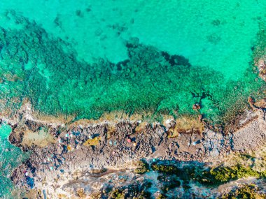 İtalya, Sardunya 'da güneşlenen ve dinlenen insanların bulunduğu kıyı şeridi insansız hava aracı görüntüsü